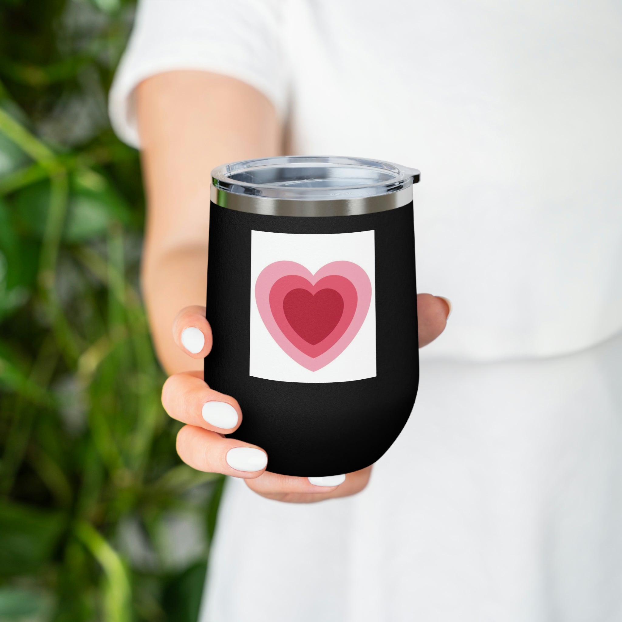 A stylish Hearts Wine Tumbler made of stainless steel with a clear plastic lid, perfect for hot and cold beverages.