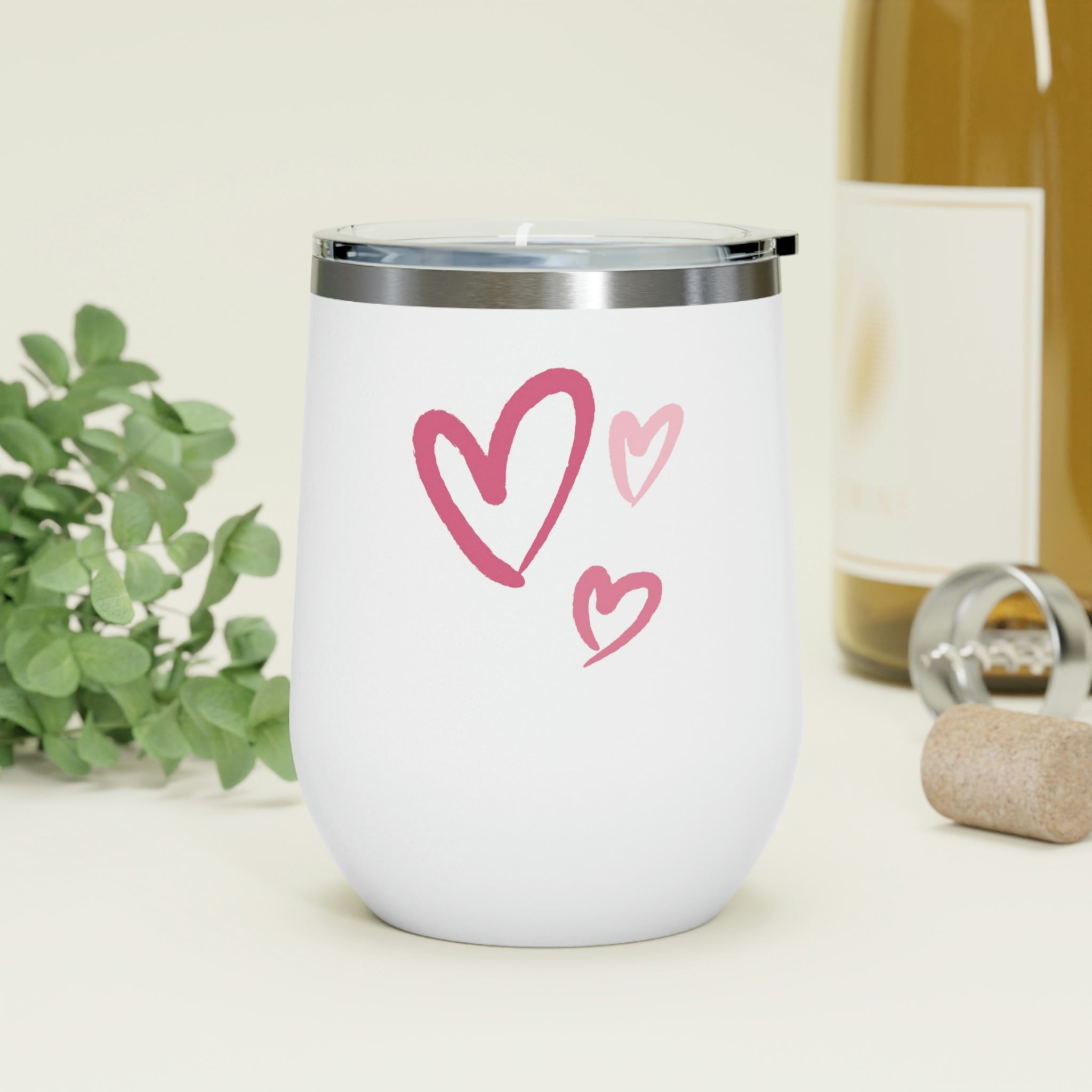 A stylish Hearts Wine Tumbler made of stainless steel with a clear plastic lid, showcasing a heart design, perfect for hot and cold beverages.