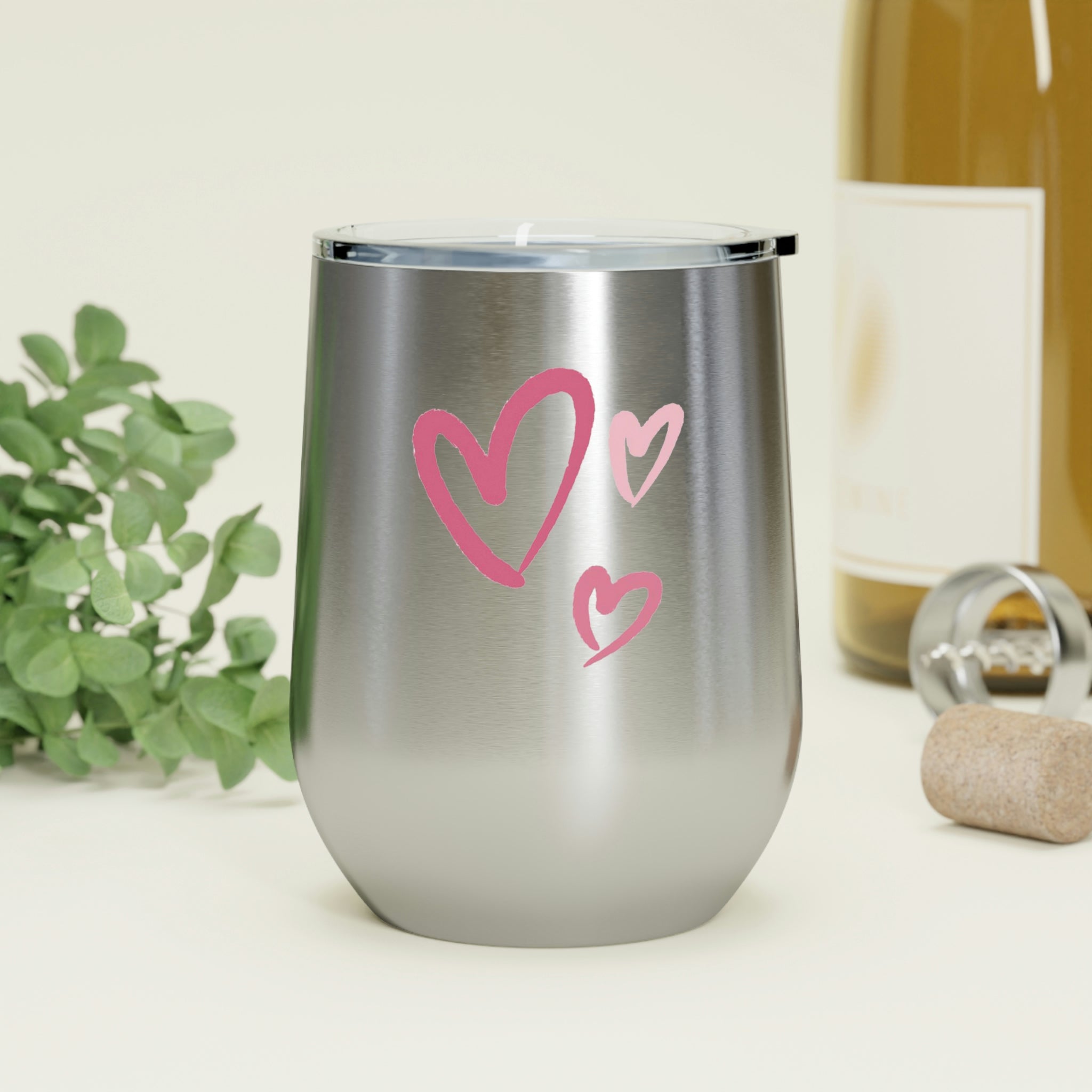 A stylish Hearts Wine Tumbler made of stainless steel with a clear plastic lid, showcasing a heart design, perfect for hot and cold beverages.