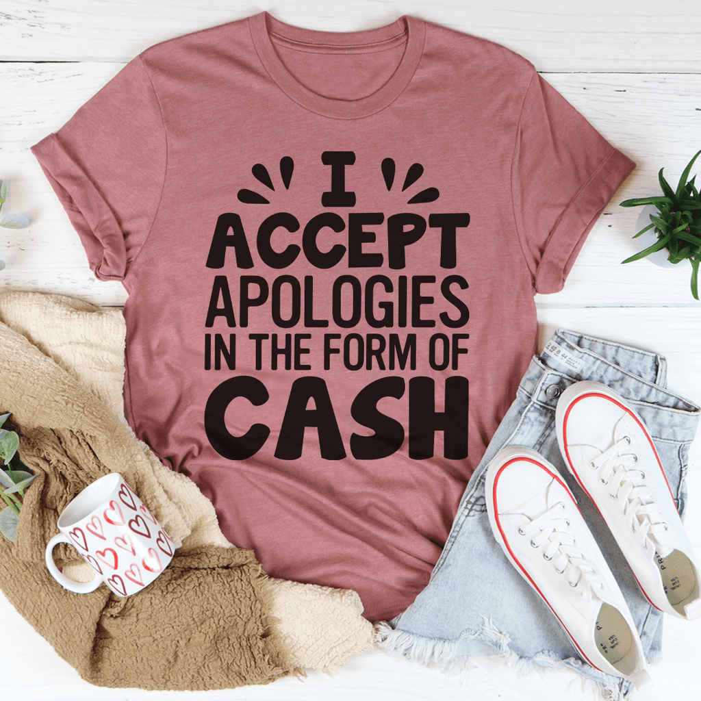 A humorous t-shirt featuring the phrase 'I Accept Apologies In The Form Of Cash', made from soft cotton with double stitching.