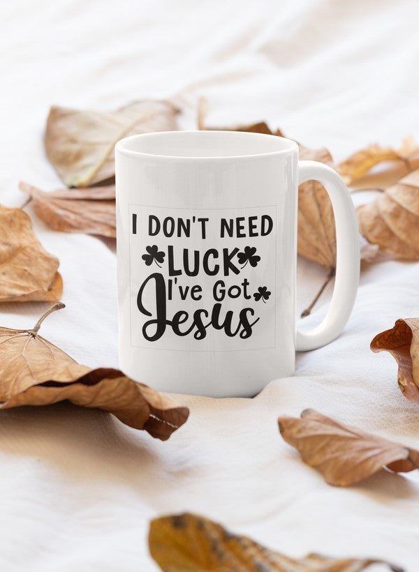 A glossy white ceramic mug featuring the phrase 'I Don't Need Luck I've Got Jesus' in bold lettering, perfect for coffee or tea.