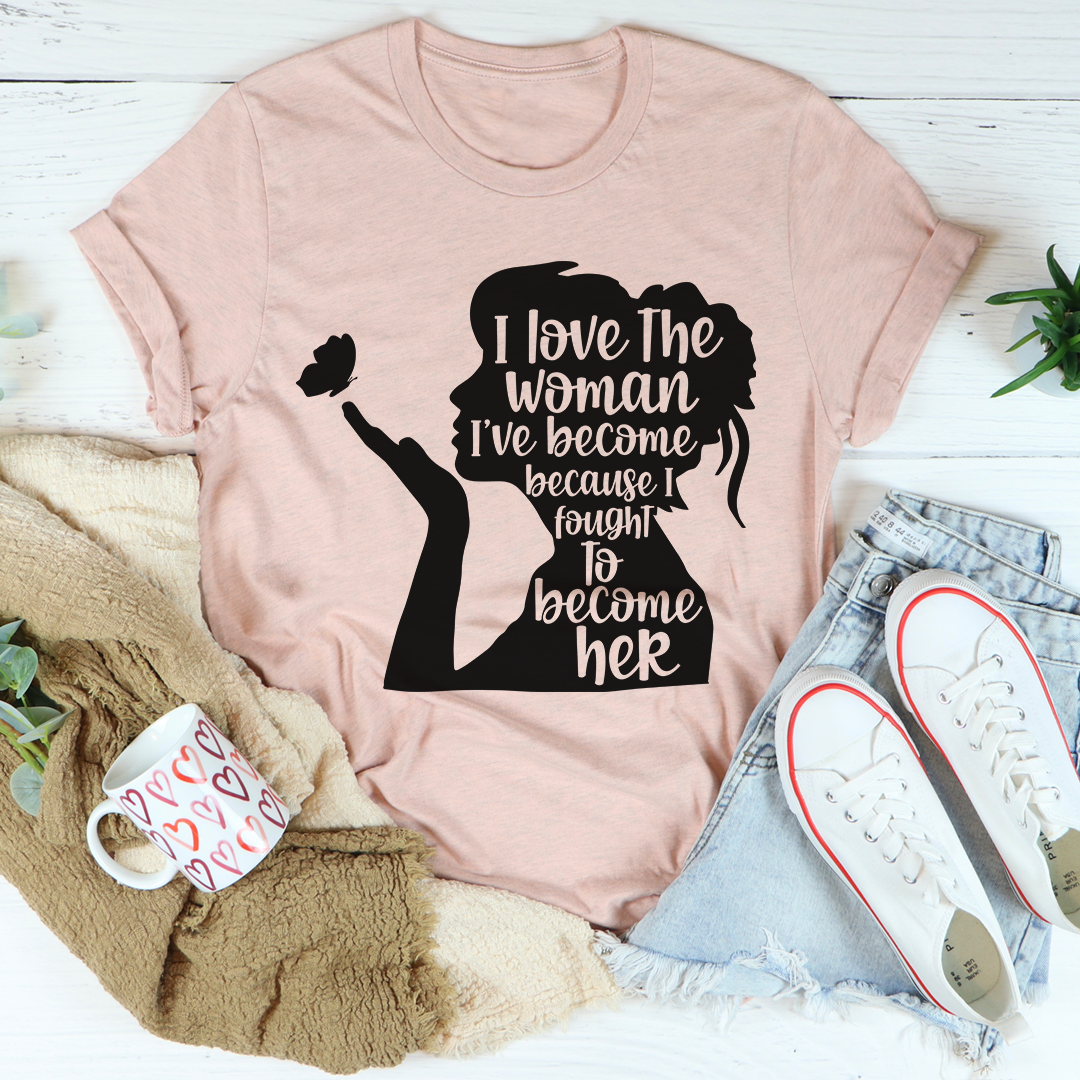 A stylish black t-shirt with the phrase 'I Love The Woman I've Become' printed in elegant font, showcasing its soft fabric and durable stitching.