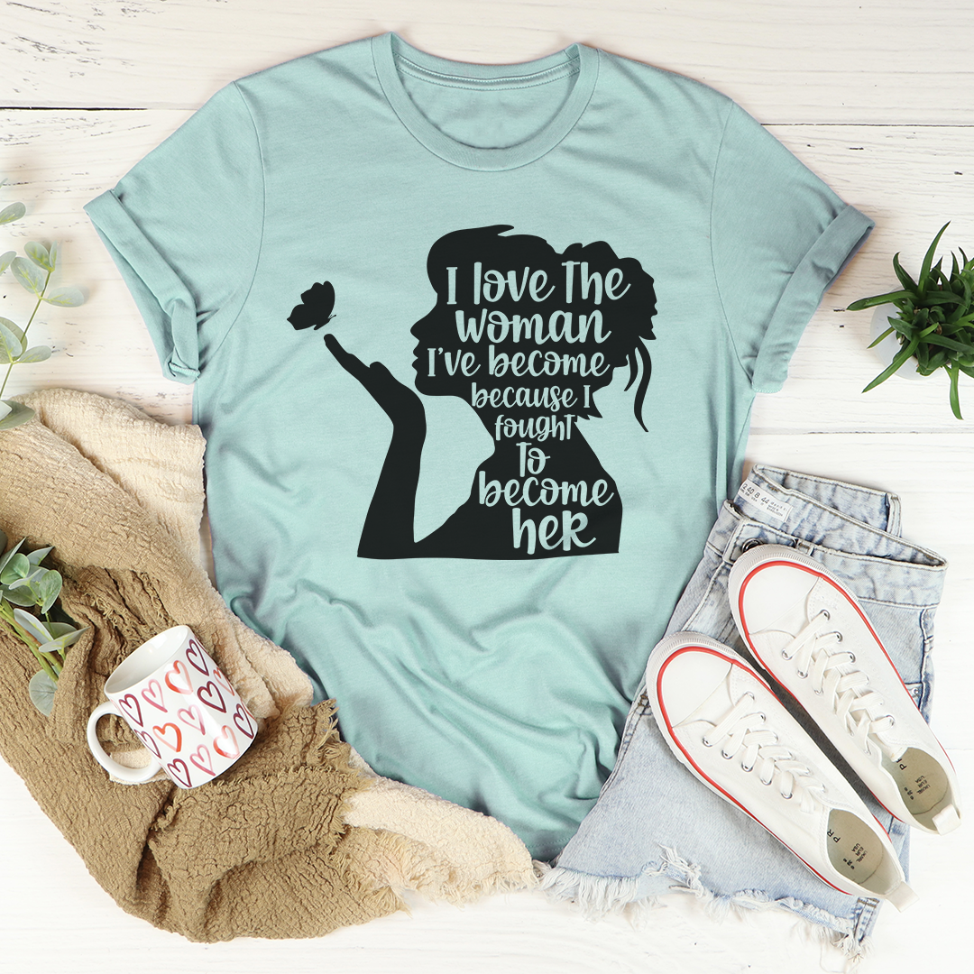 A stylish black t-shirt with the phrase 'I Love The Woman I've Become' printed in elegant font, showcasing its soft fabric and durable stitching.