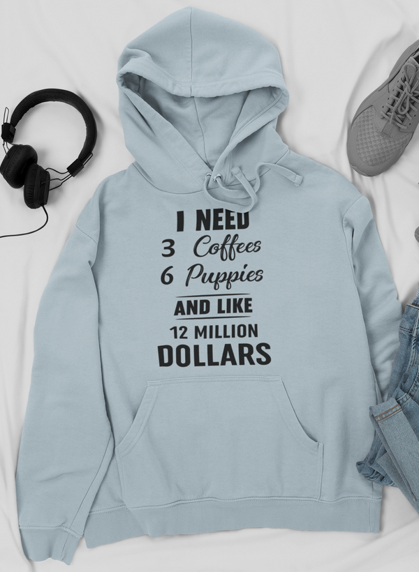 A cozy hoodie featuring the phrase 'I Need 3 Coffees 6 Puppies And Like 12 Million Dollars' designed for comfort and style.