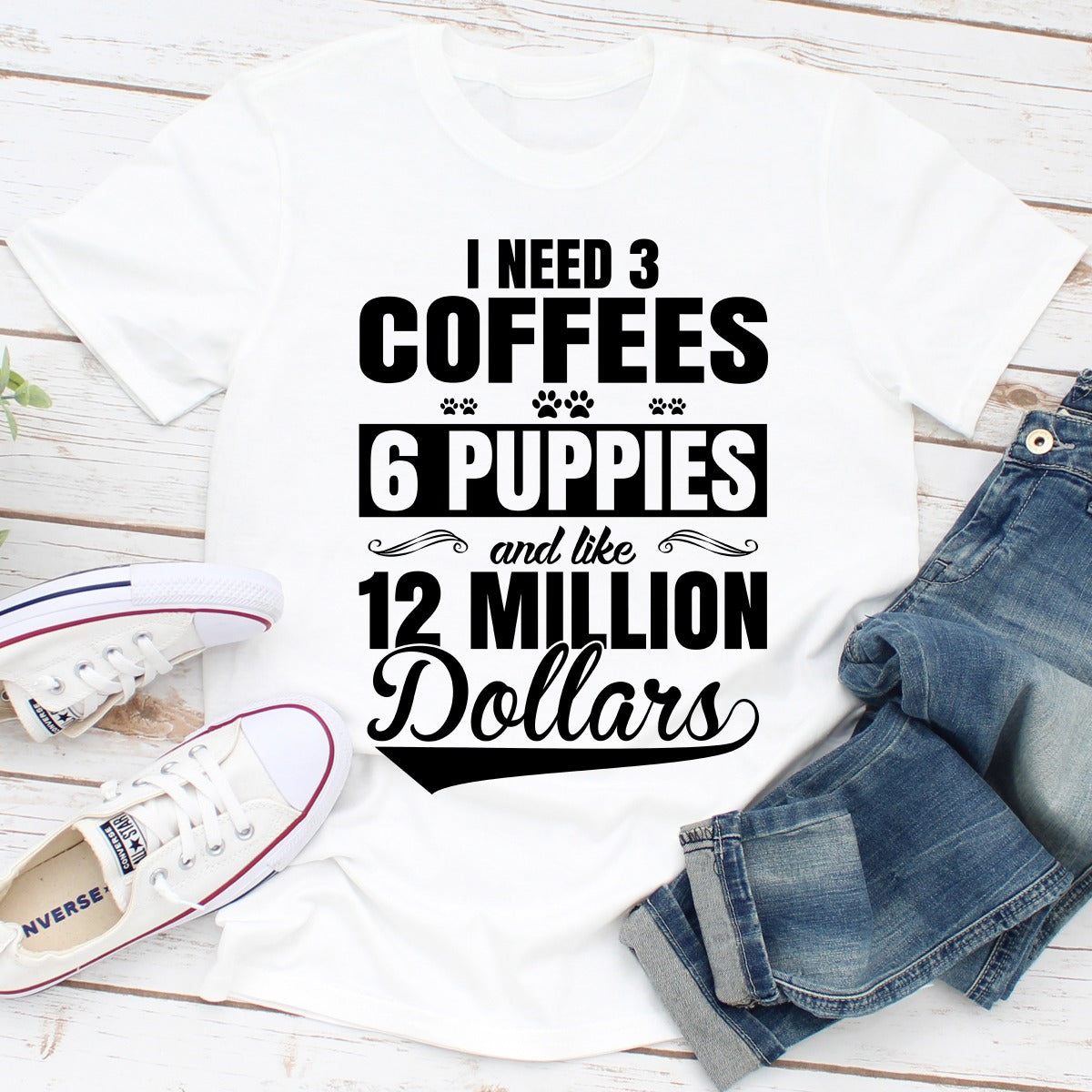 I Need 3 Coffees 6 Puppies And Like 12 Million Dollars T-Shirt displayed on a mannequin, showcasing its soft cotton fabric and unique design.