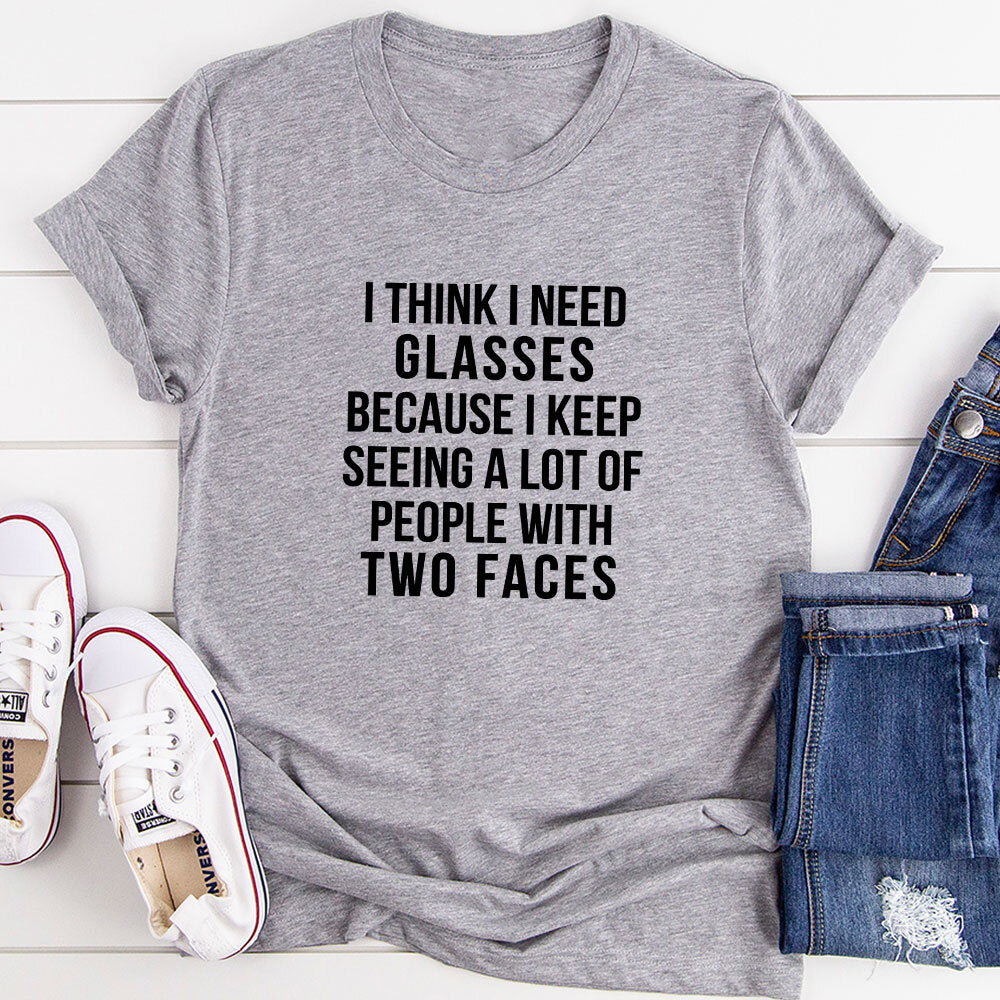 A humorous t-shirt featuring the phrase 'I Think I Need Glasses Because I Keep Seeing A Lot Of People With Two', made from soft cotton.