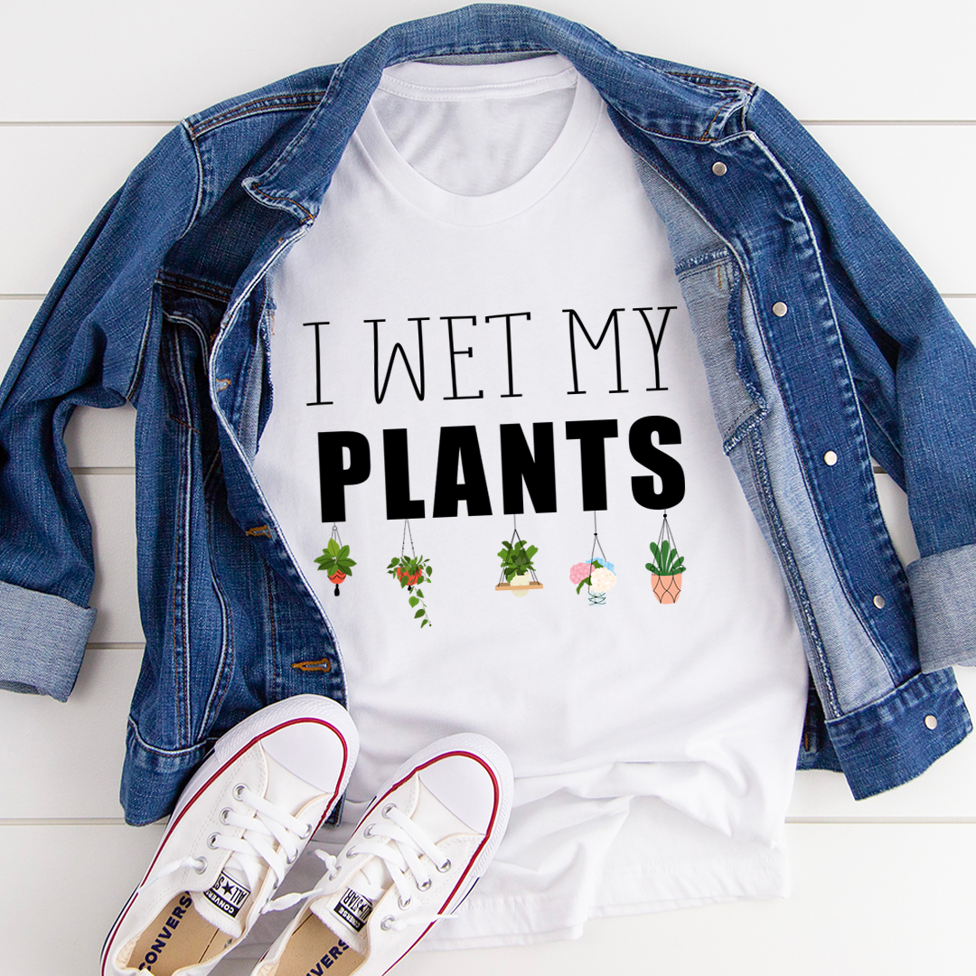 I Wet My Plants T-Shirt displayed on a hanger, showcasing its soft cotton fabric and humorous design.