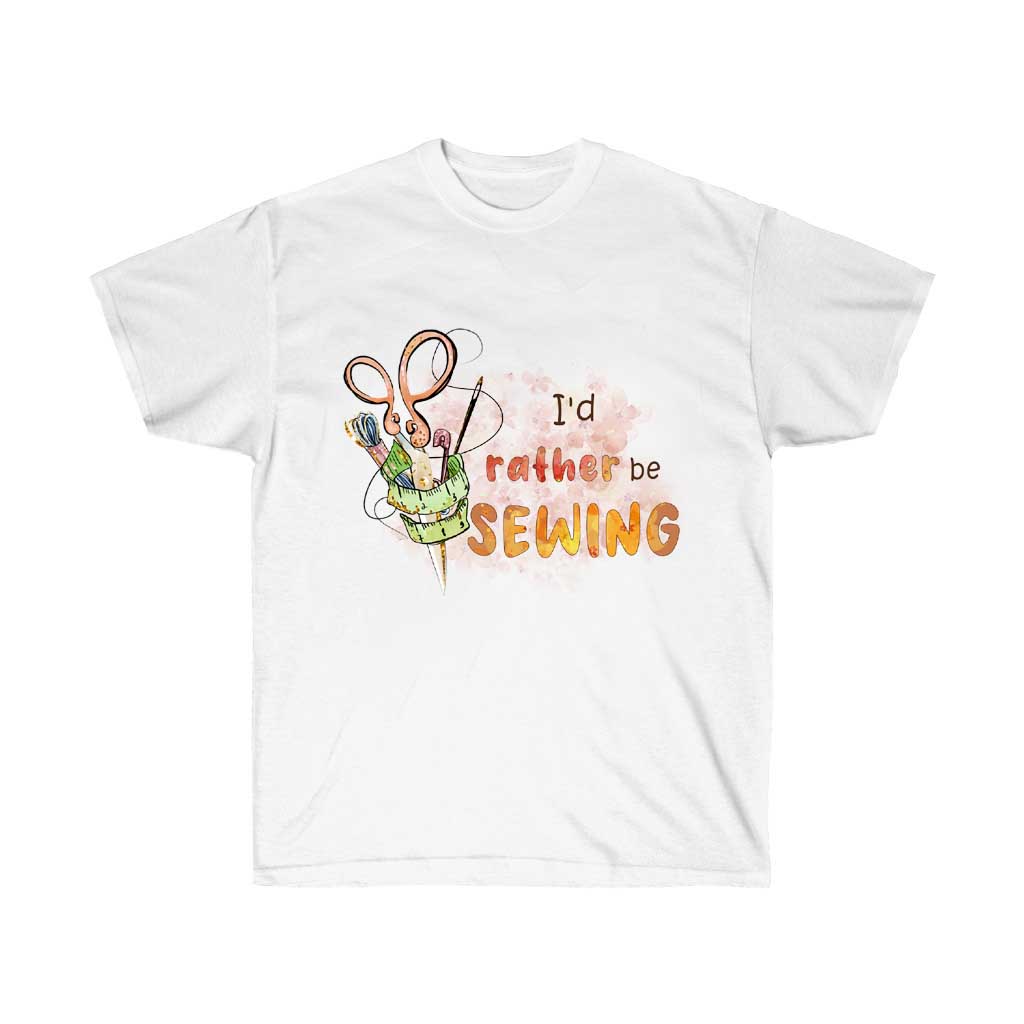 A white unisex t-shirt with the phrase 'I'd Rather Be Sewing' printed in a stylish font, made from 100% soft cotton.