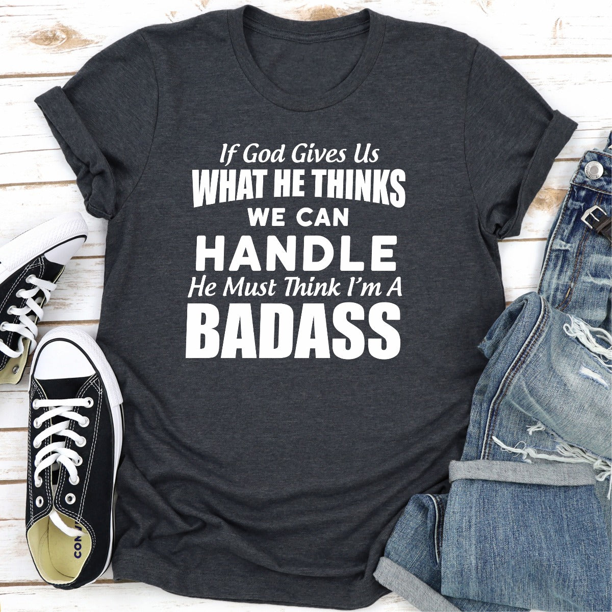 A stylish black t-shirt featuring the phrase 'If God Give Us What He Think We Can Handle He Must Think I'm A Badass' in bold lettering.