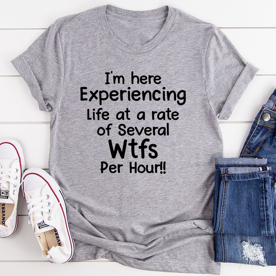 A humorous t-shirt featuring the phrase 'I'm Here Experiencing Life At A Rate of Several WTFs Per Hour', made from soft cotton.