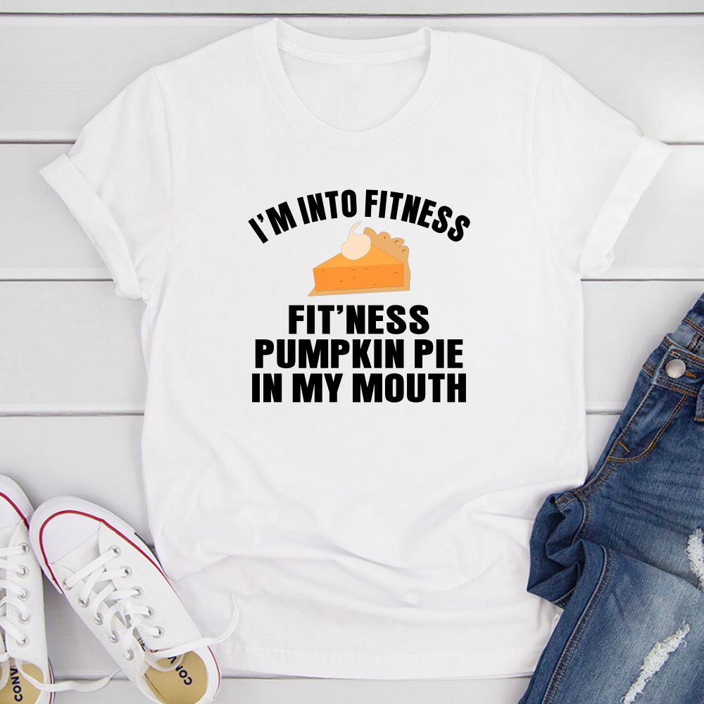 A humorous t-shirt featuring the phrase 'I'm Into Fitness... Fit'ness Pumpkin Pie In My Mouth' printed on a soft cotton fabric.