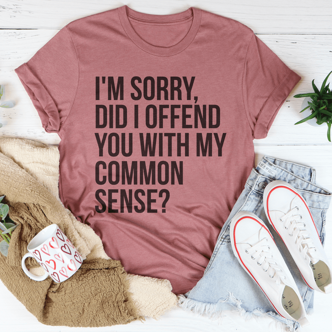 A stylish black t-shirt featuring the phrase 'I'm Sorry Did I Offend You With My Common Sense' printed in bold letters, showcasing its soft fabric and durable stitching.