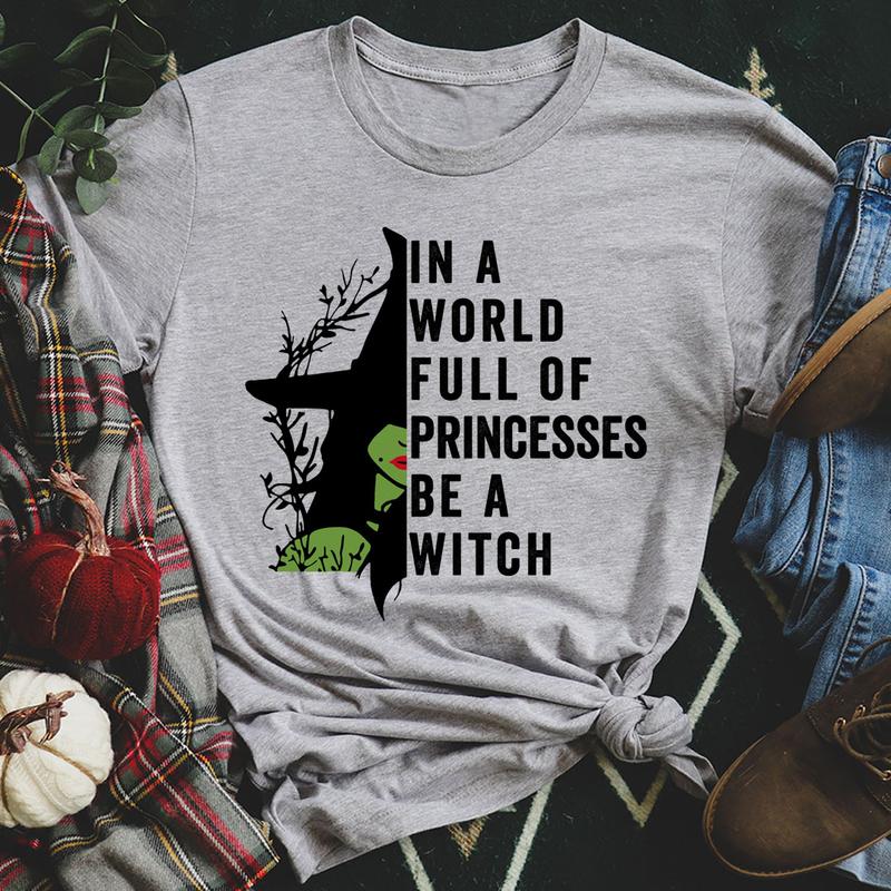 A stylish black t-shirt featuring the phrase 'In A World Full Of Princesses Be A Witch' in bold lettering, showcasing its comfortable fit and quality fabric.