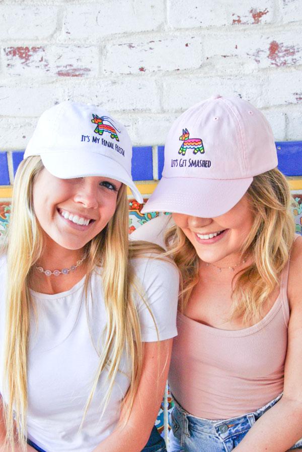 Embroidered bachelorette hats in white and soft pink with fun phrases for a fiesta theme.