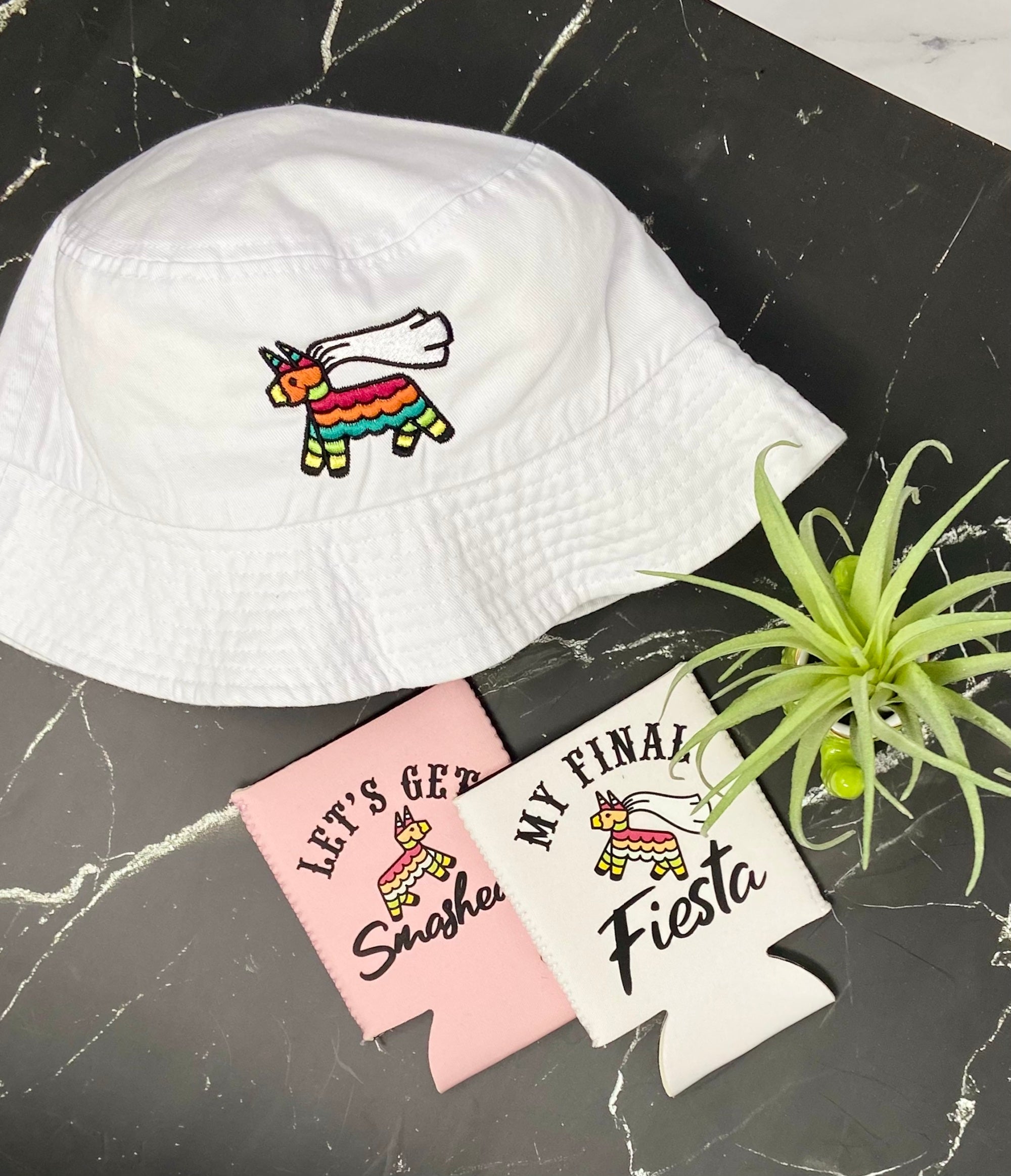 Embroidered bachelorette hats in white and soft pink with fun phrases for a fiesta theme.