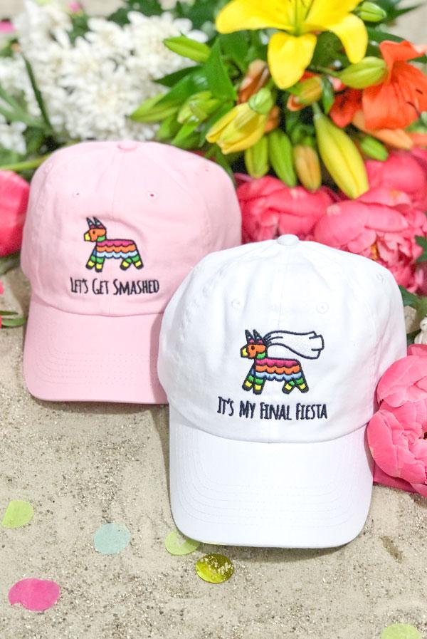 Embroidered bachelorette hats in white and soft pink with fun phrases for a fiesta theme.