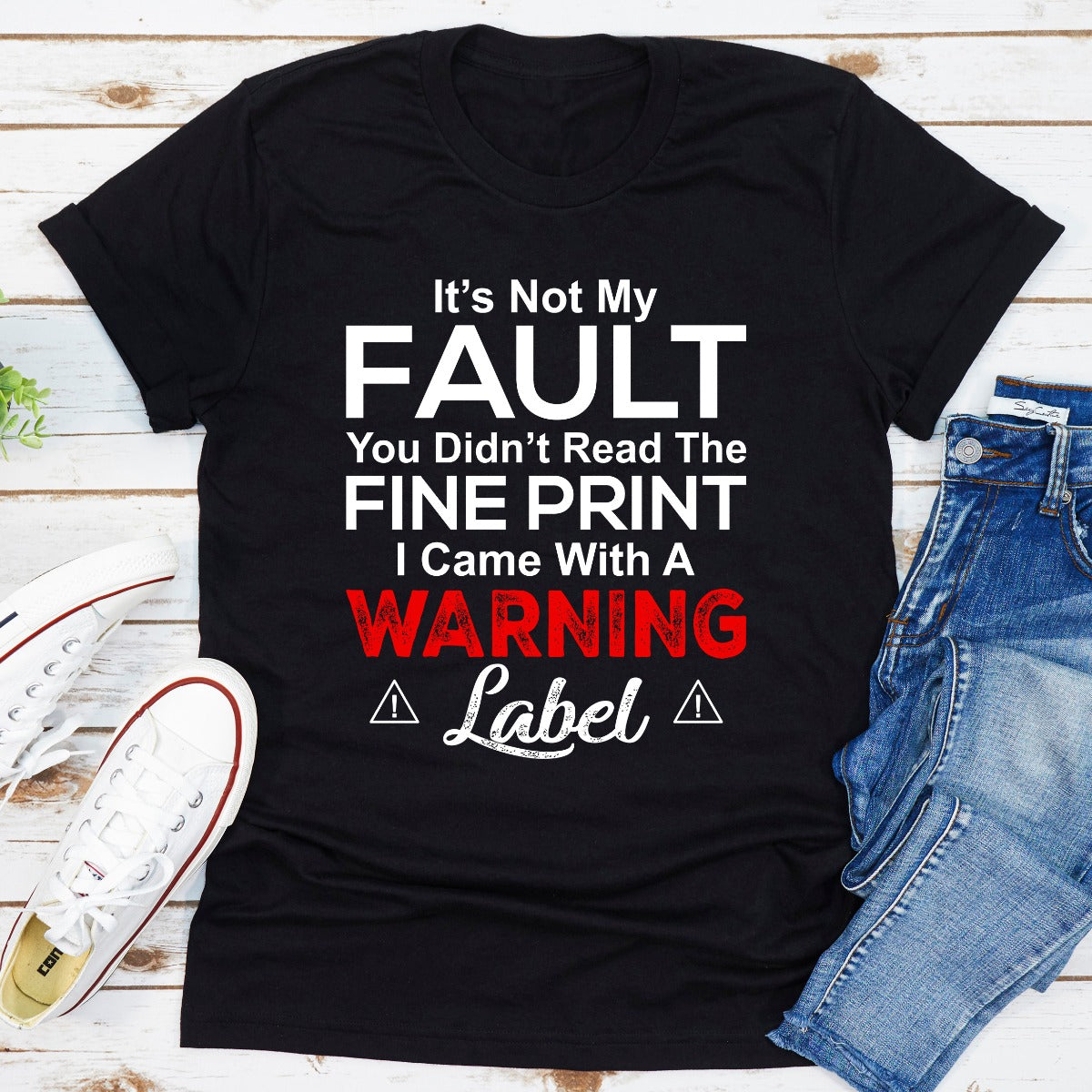 A stylish black t-shirt featuring the phrase 'It's Not My Fault You Didn't Read The Fine Print' printed in bold letters, showcasing its comfortable fit and quality fabric.