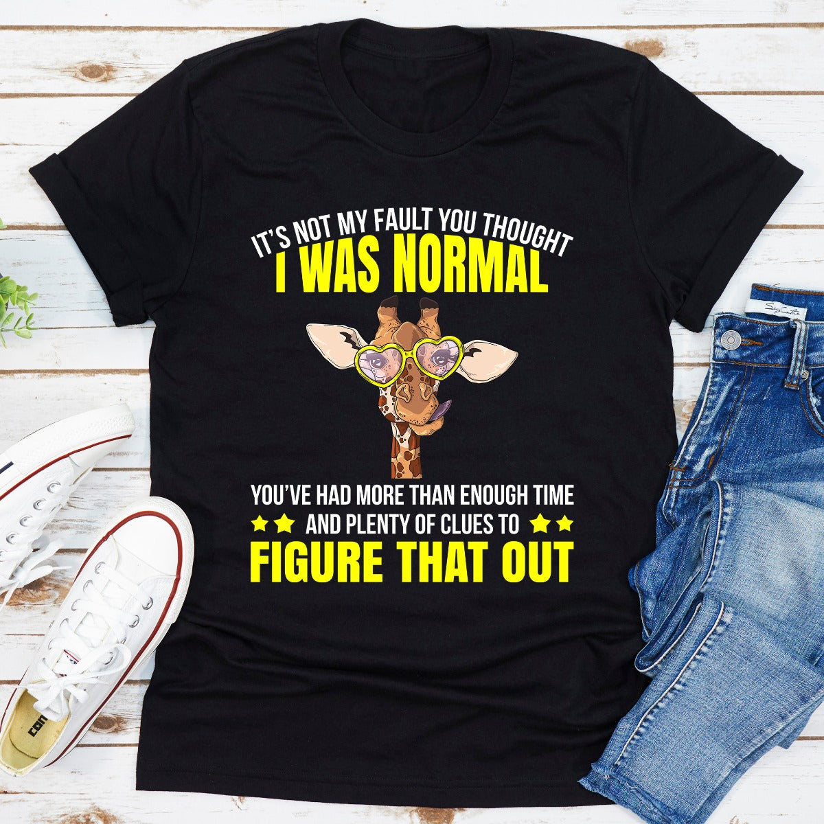 A stylish black t-shirt featuring the phrase 'It's Not My Fault You Thought I Was Normal' in bold white lettering, showcasing its comfortable fit and quality fabric.