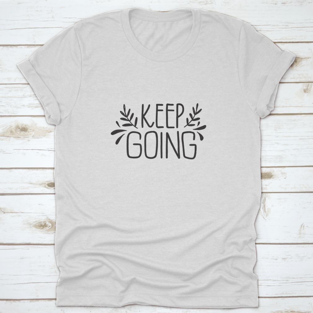 A stylish shirt featuring hand-drawn lettering that says 'Keep Going', showcasing modern brush calligraphy on a comfortable fabric.