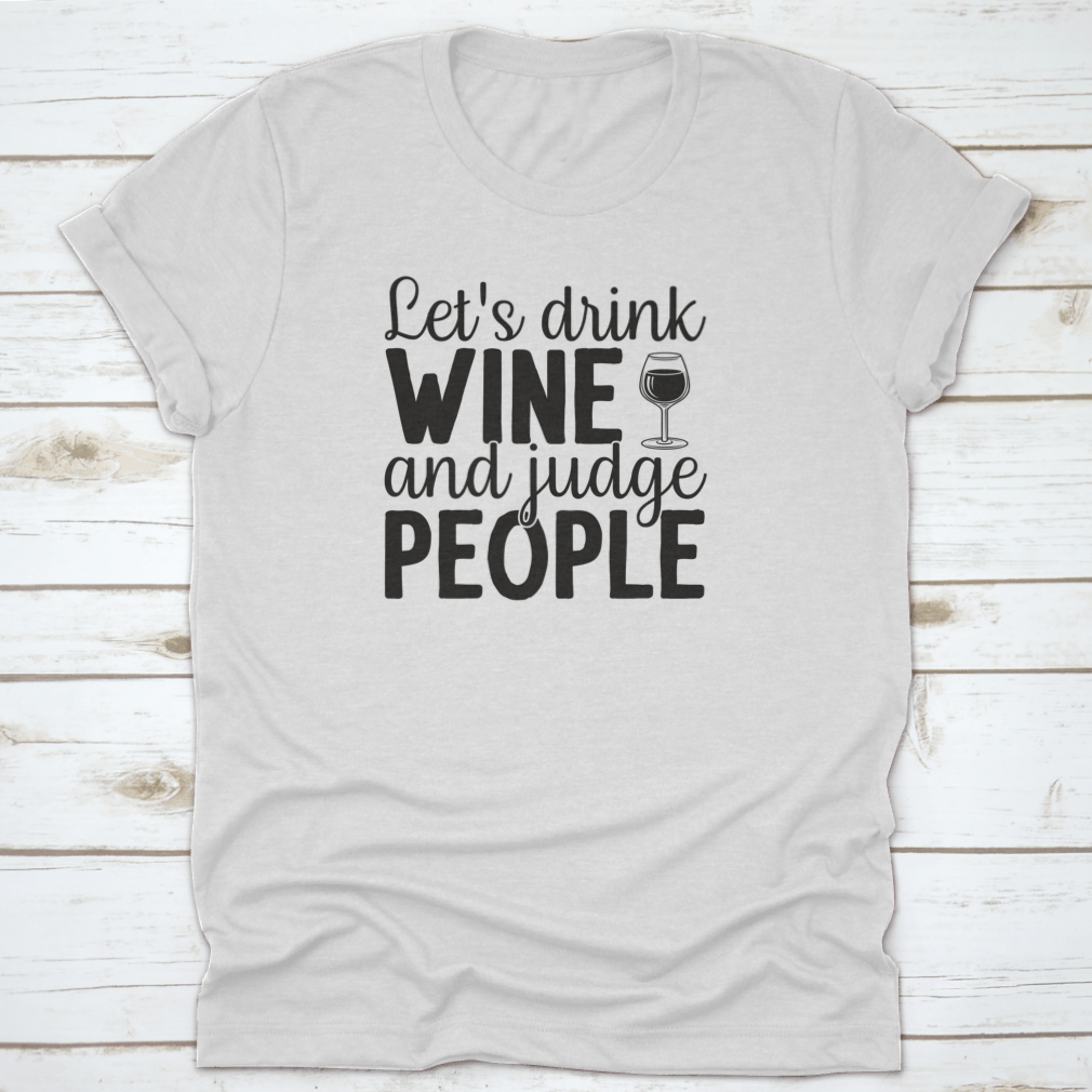 A humorous t-shirt featuring the phrase 'Let's Drink Wine And Judge People', showcasing a casual and stylish design suitable for wine lovers.