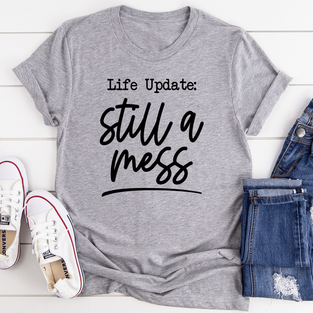 Life Update Still A Mess T-Shirt displayed on a mannequin, showcasing its soft cotton fabric and stylish design.