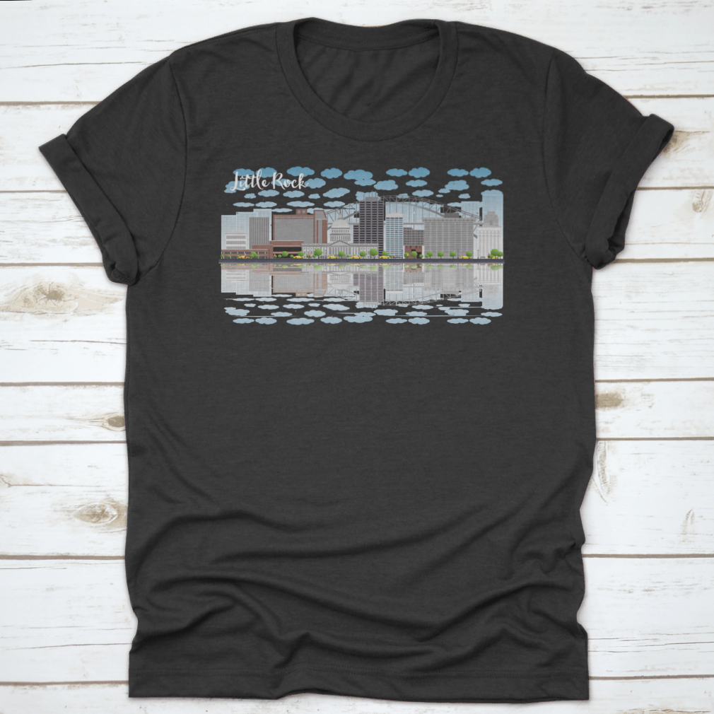 A stylish T-shirt featuring the Little Rock skyline with a grey building, blue sky, and reflections, showcasing urban beauty.