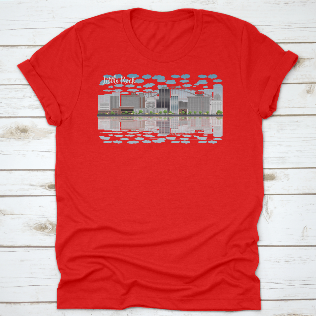 A stylish T-shirt featuring the Little Rock skyline with a grey building, blue sky, and reflections, showcasing urban beauty.