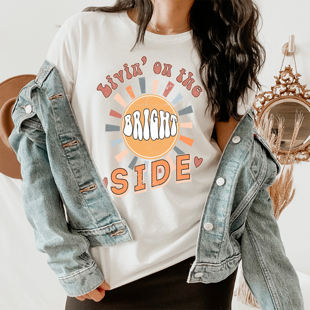 Livin' On The Bright Side T-Shirt in vibrant colors, showcasing its soft fabric and double stitching details.