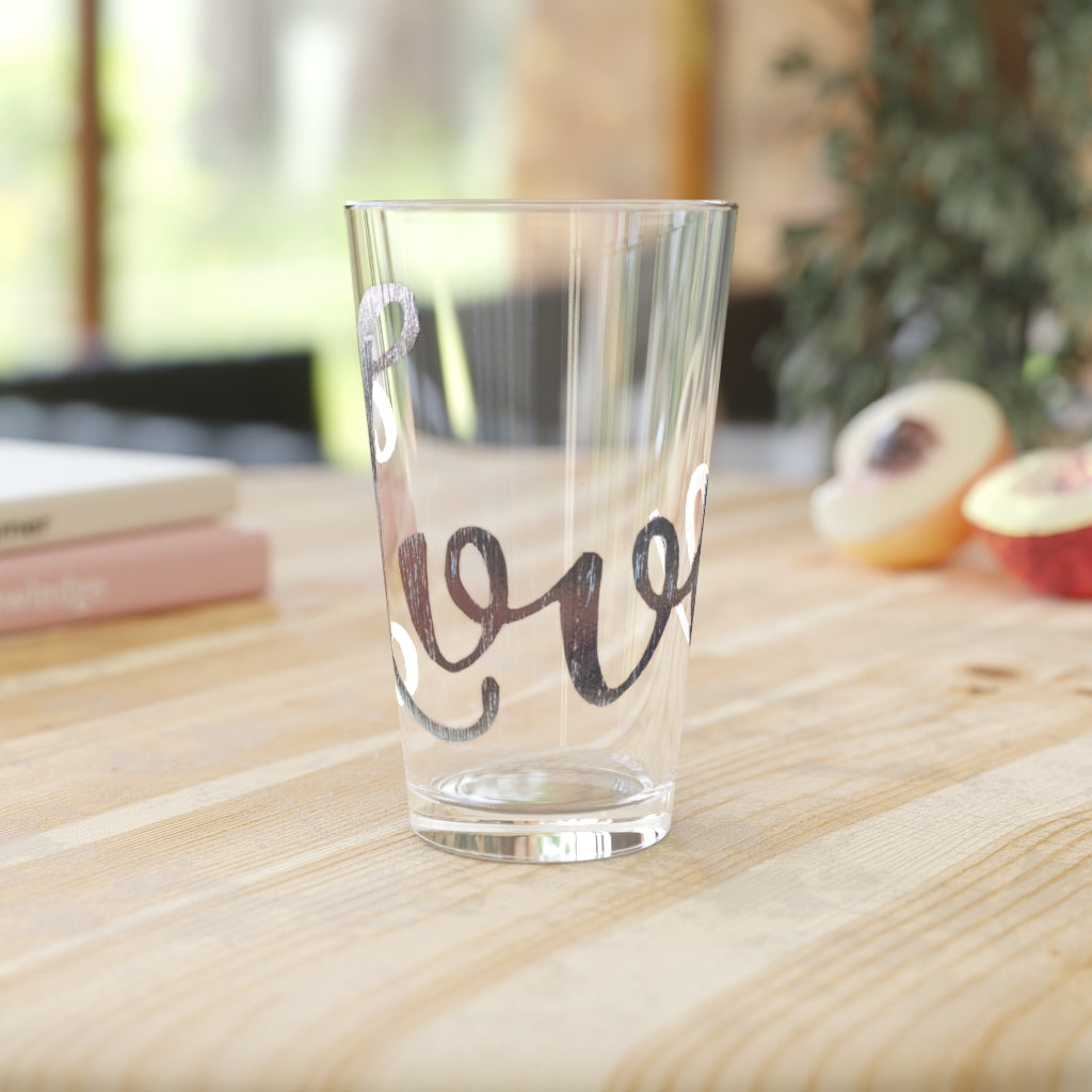 A clear 16oz Love Pint Glass showcasing a personalized design, perfect for beverages.