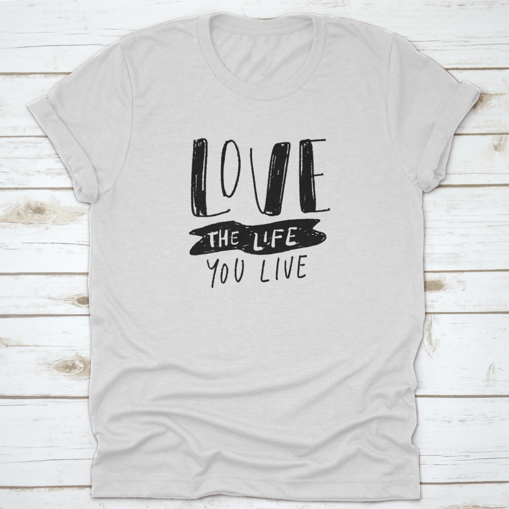 Hand lettering illustration saying 'Love The Life You Live' on a soft cotton fabric, showcasing its design and quality.