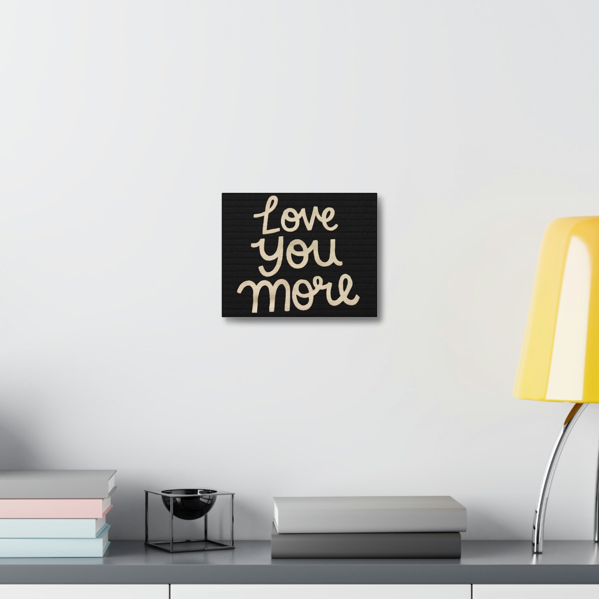 Love You More Stretched Canvas art piece featuring a heartfelt message, elegantly stretched on a wooden frame.