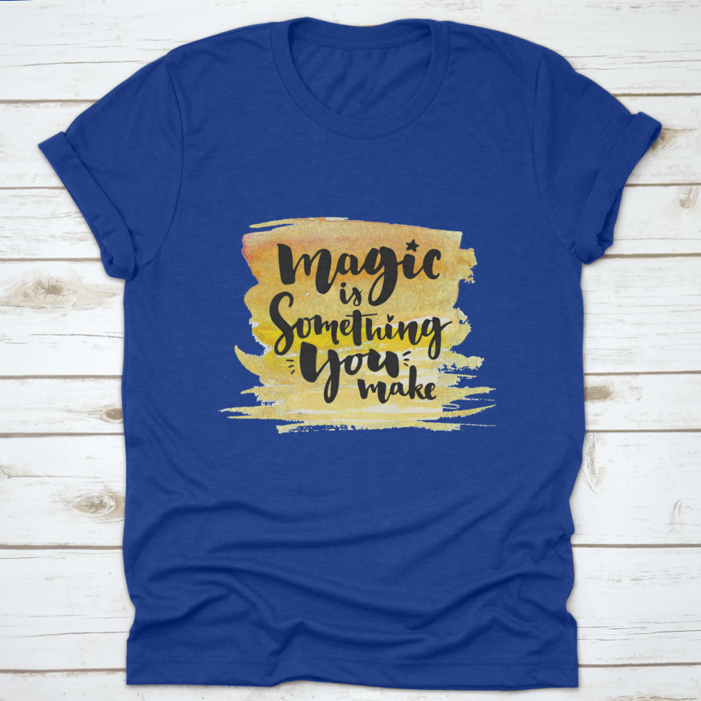 A vibrant yellow watercolor background featuring the phrase 'Magic Is Something You Make' in elegant brush lettering, showcasing creativity and artistic expression.