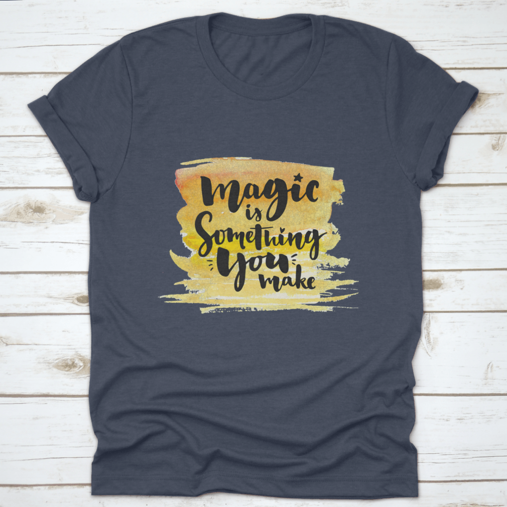 A vibrant yellow watercolor background featuring the phrase 'Magic Is Something You Make' in elegant brush lettering, showcasing creativity and artistic expression.