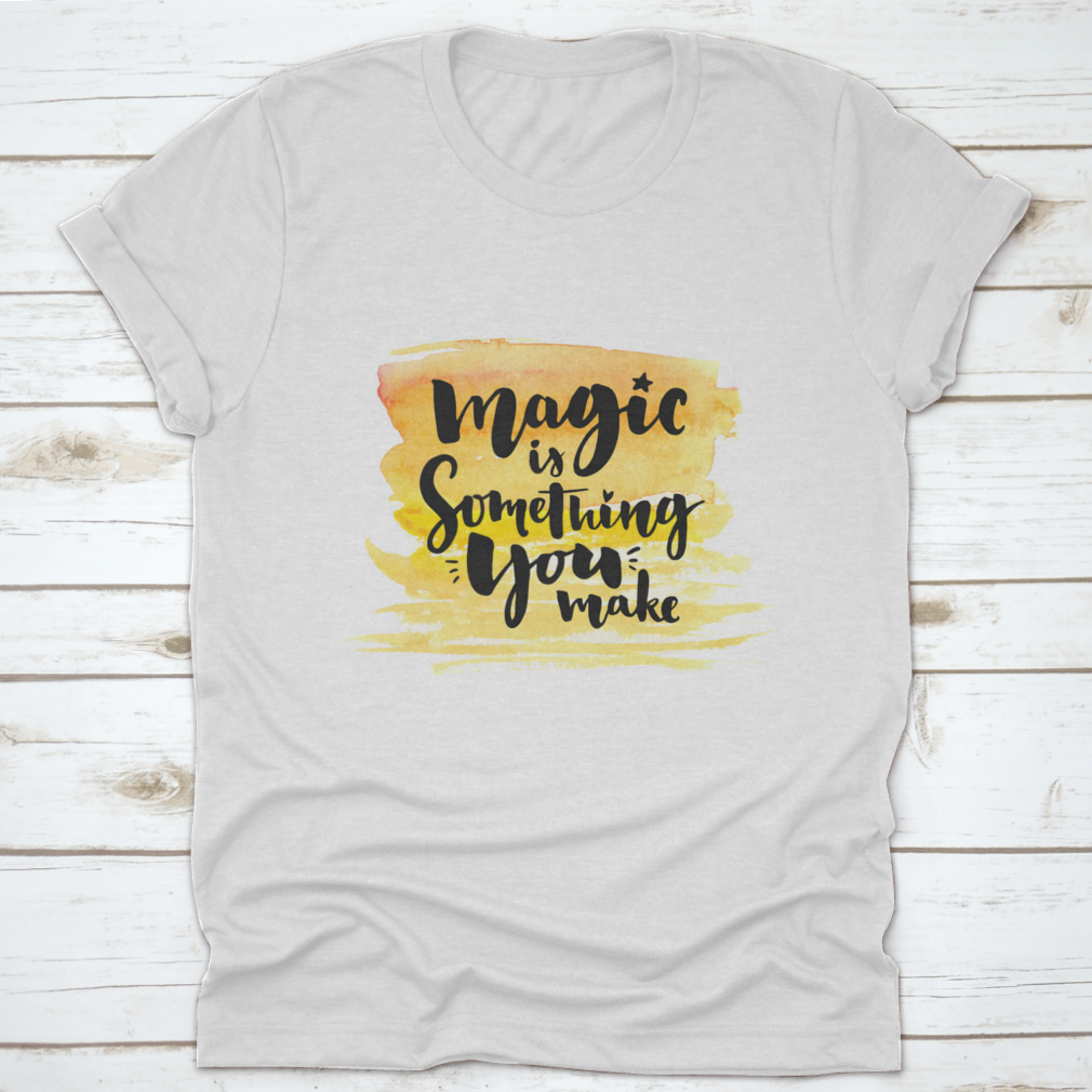 A vibrant yellow watercolor background featuring the phrase 'Magic Is Something You Make' in elegant brush lettering, showcasing creativity and artistic expression.