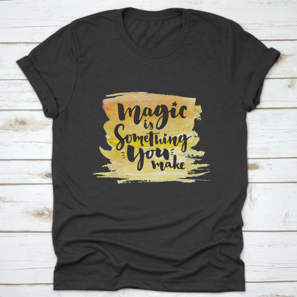 A vibrant yellow watercolor background featuring the phrase 'Magic Is Something You Make' in elegant brush lettering, showcasing creativity and artistic expression.