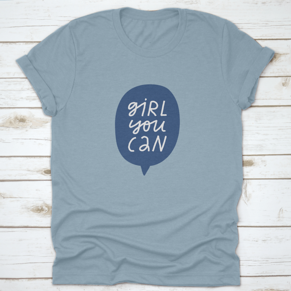 A stylish t-shirt featuring minimalist hand-drawn lettering in a blue speech bubble that reads 'Girl You Can', showcasing a casual and empowering design.