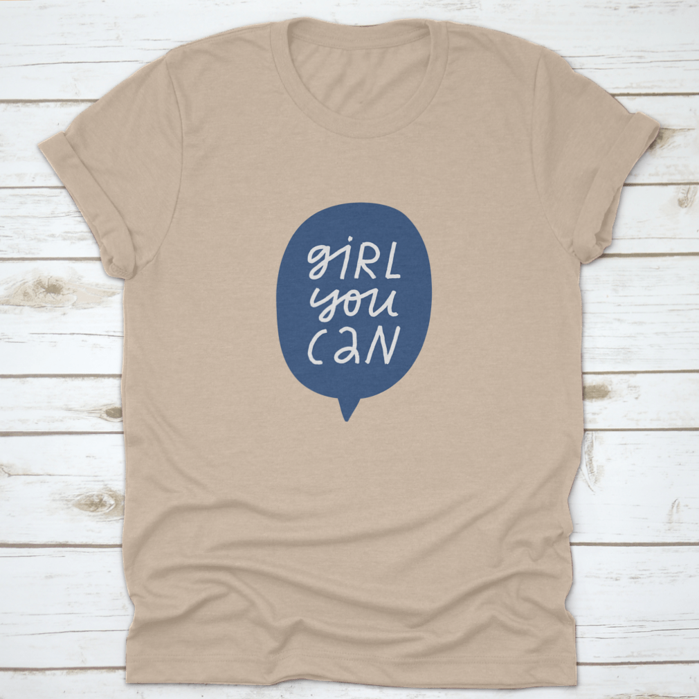 A stylish t-shirt featuring minimalist hand-drawn lettering in a blue speech bubble that reads 'Girl You Can', showcasing a casual and empowering design.