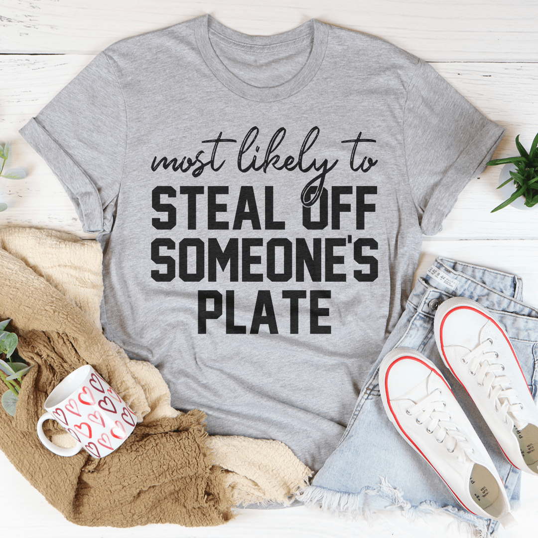 A comfortable Thanksgiving t-shirt featuring the phrase 'Most Likely To Steal Off Someone's Plate', made from soft cotton.