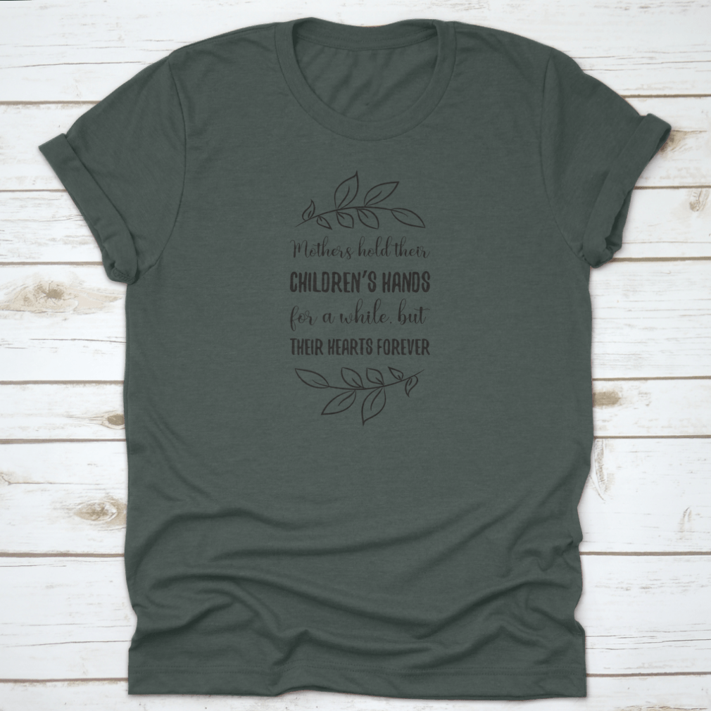 A soft cotton t-shirt featuring the phrase 'Mothers Hold Their Children’s Hands For A While, But Their Hearts', showcasing a classic fit and durable design.