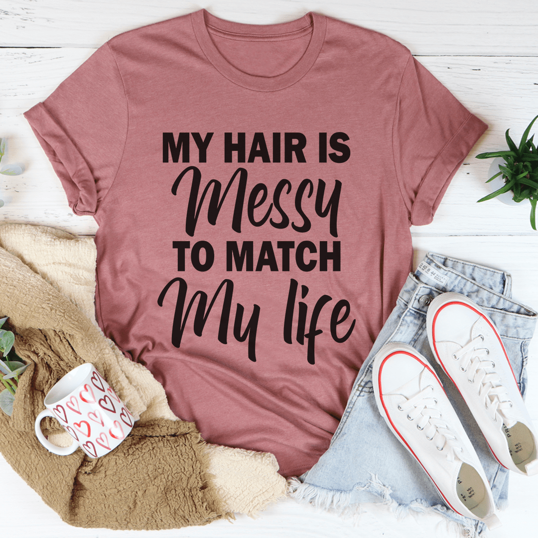 A stylish t-shirt with the phrase 'My Hair Is Messy To Match My Life' printed on it, showcasing its soft fabric and durable stitching.