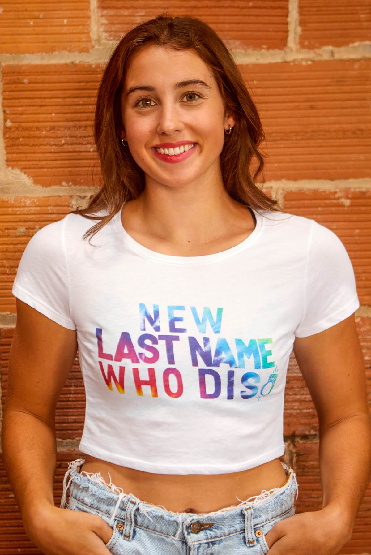 A vibrant white shirt featuring the phrase 'New Last Name Who Dis' in a colorful tie-dye print, perfect for brides.