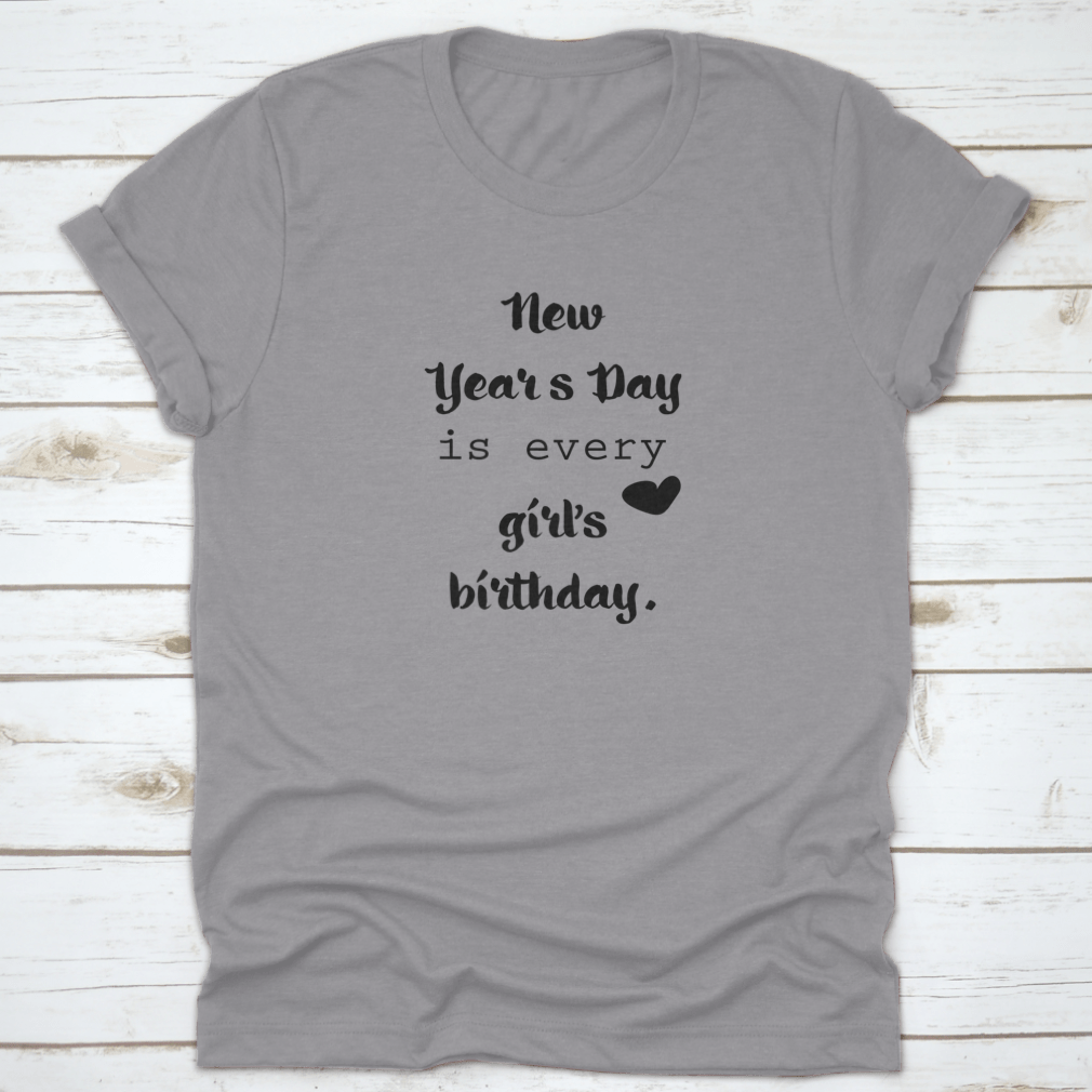 A motivational t-shirt featuring the quote 'New Year's Day Is Every Girl's Birthday', made from 100% cotton, displayed on a neutral background.