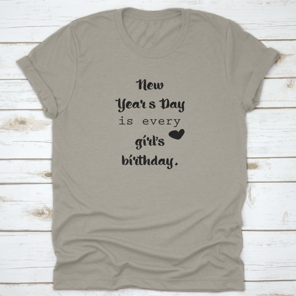 A motivational t-shirt featuring the quote 'New Year's Day Is Every Girl's Birthday', made from 100% cotton, displayed on a neutral background.