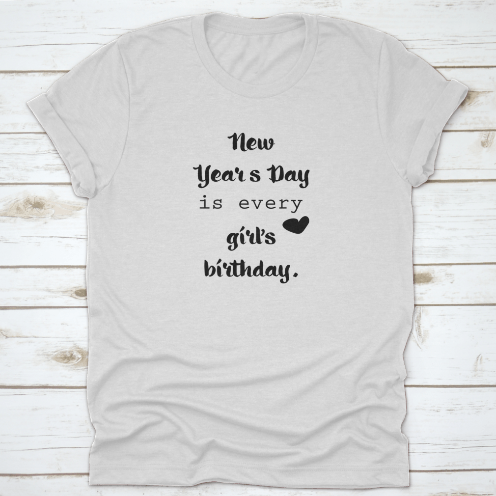 A motivational t-shirt featuring the quote 'New Year's Day Is Every Girl's Birthday', made from 100% cotton, displayed on a neutral background.