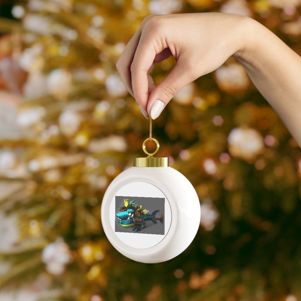 A 3-inch glossy Christmas ball ornament featuring Nibblers the Misfit Shark, adorned with a gold ribbon for hanging.