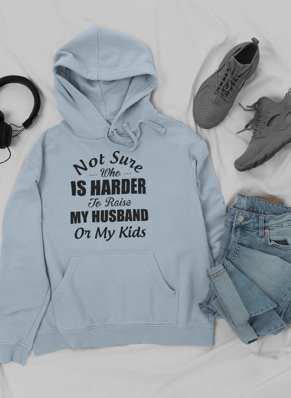 A cozy hoodie featuring the phrase 'Not Sure Who Is Harder To Raise My Husband Or My Kids', designed for parents.