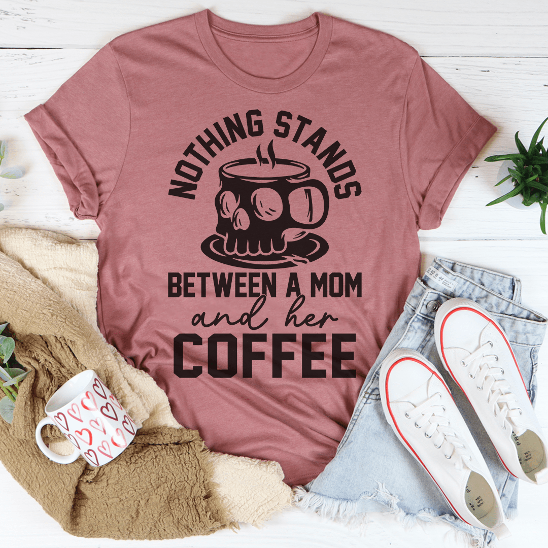 A stylish t-shirt featuring the phrase 'Nothing Stands Between A Mom & Her Coffee', made from soft cotton with double stitching.