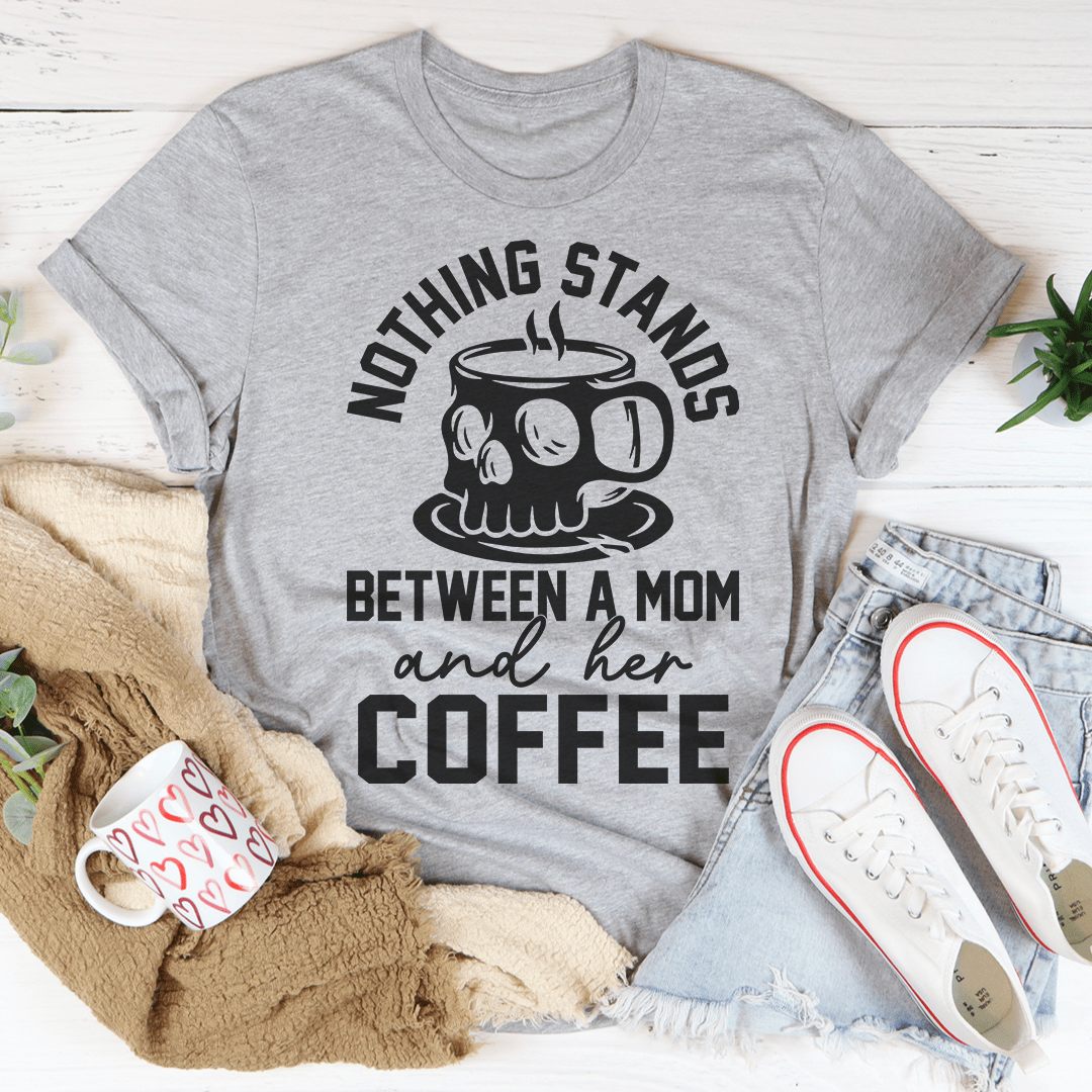 A stylish t-shirt featuring the phrase 'Nothing Stands Between A Mom & Her Coffee', made from soft cotton with double stitching.