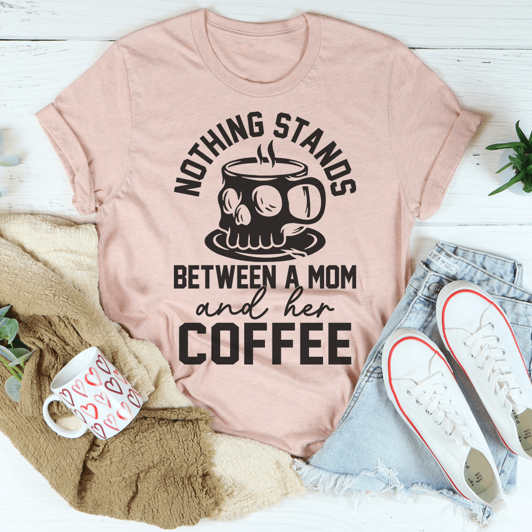 A stylish t-shirt featuring the phrase 'Nothing Stands Between A Mom & Her Coffee', made from soft cotton with double stitching.