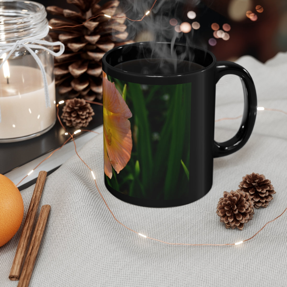 Peach and yellow flower design on a black ceramic mug, perfect for coffee or tea.